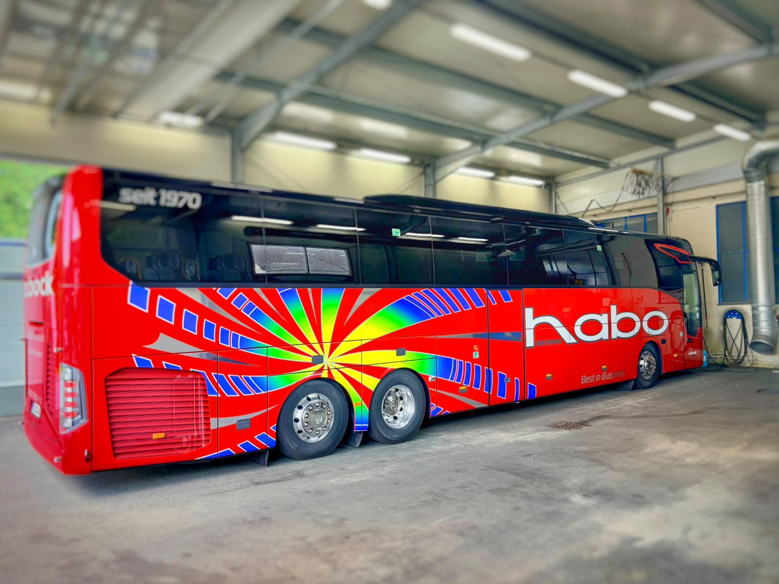 Mehrfarbig folierter Habo-Reisebus in einer Werkstatthalle